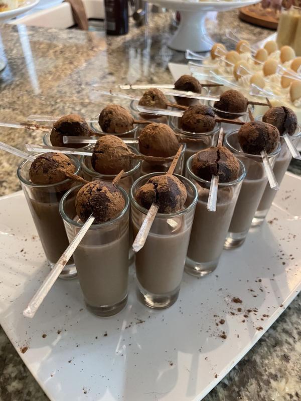 Chocolate shooters in small glasses, each topped with a bourbon truffle on a stick