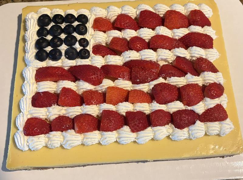 Key lime pie decorated as an American flag with blueberries, strawberries and piped whipped cream