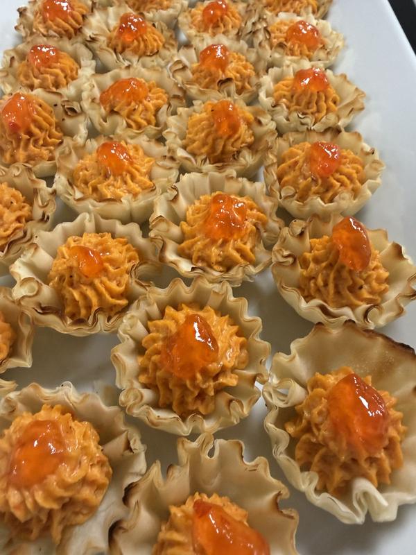 Crisp phyllo cups filled with a piped orange filling and topped with a red glaze