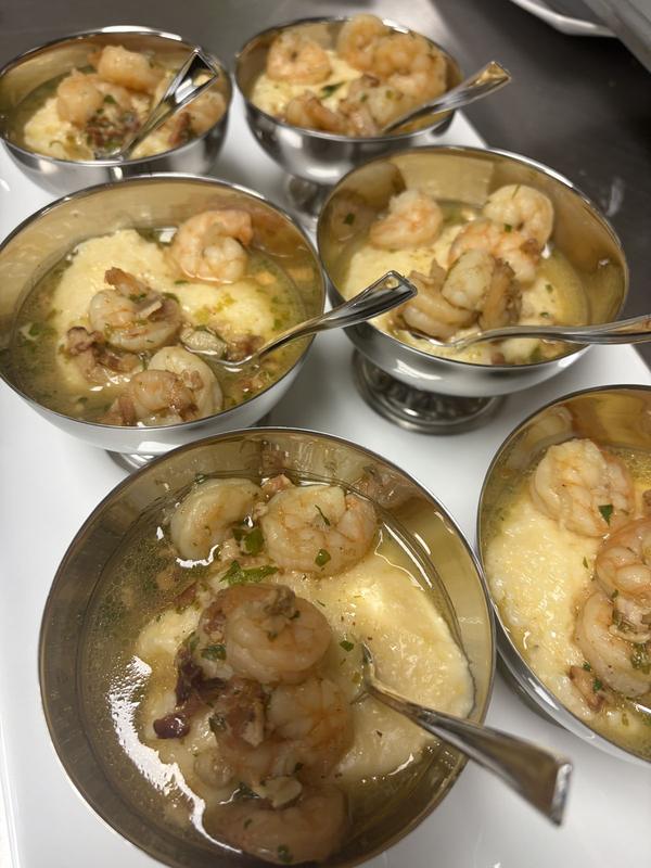 Shrimp and grits served in individual silver cups
