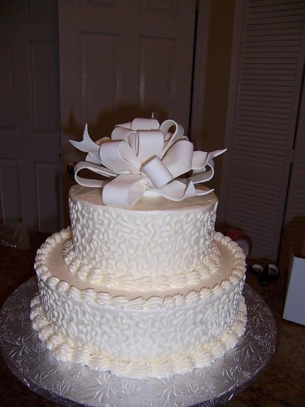 Two-tier white cake topped with a bow