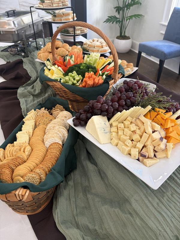 Bread, crackers, cheese and grapes with a vegetable basket