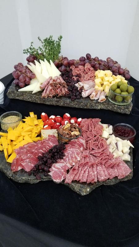 Two charcuterie boards of cured meats and cheeses