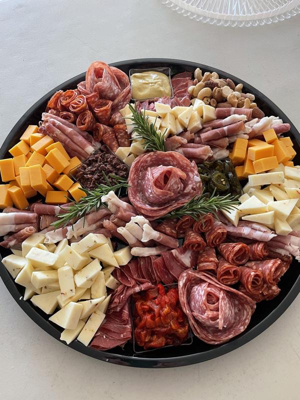 Round charcuterie platter with salami roses and cubed cheeses