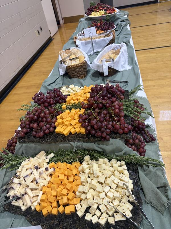Long table of cheeses and grapes