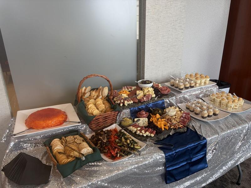 Varied catered spread with charcuterie, breads and desserts