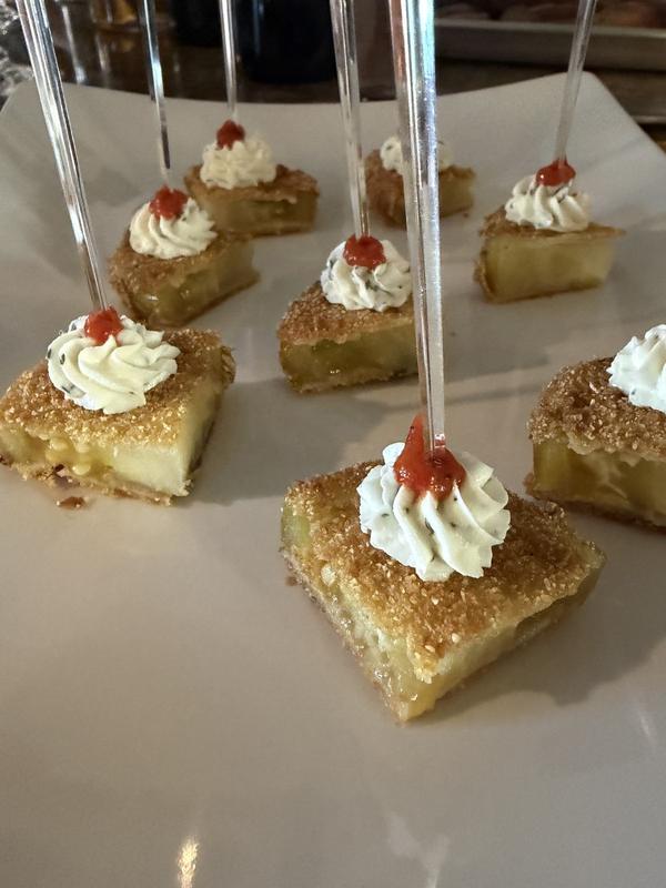 Fried green tomato squares on picks, topped with herbed cream and red pepper jelly