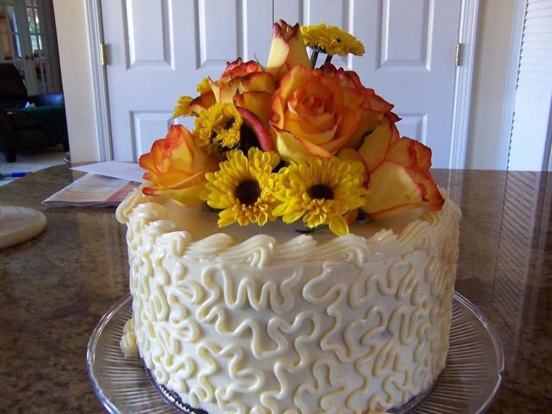 Cake topped with orange and yellow flowers