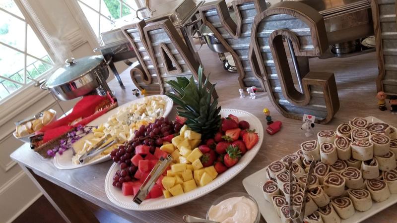 Fresh fruit platter and appetizers at a celebration with balloon letters