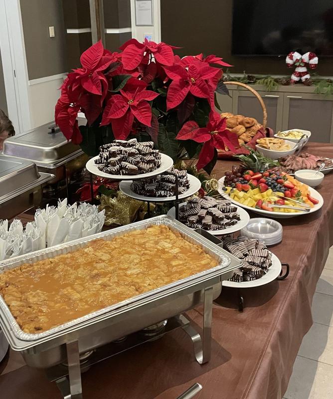 Holiday buffet with a chafing dish and desserts beside a poinsettia