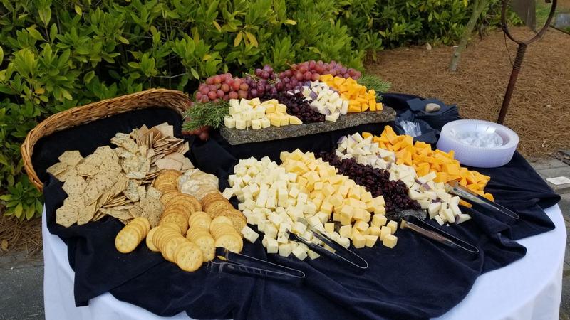 Outdoor event table with cheeses, crackers and grapes