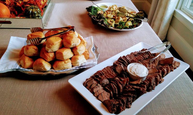 Sliced roast beef served with a basket of dinner rolls