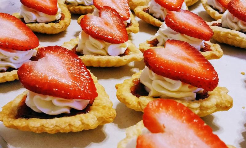 Close-up of tartlets filled with cream and topped with fresh strawberries