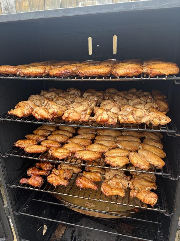 Chicken wings cooking on smoker racks
