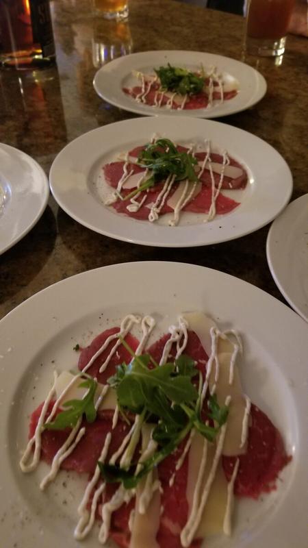 Plated beef carpaccio appetizer with fresh herbs