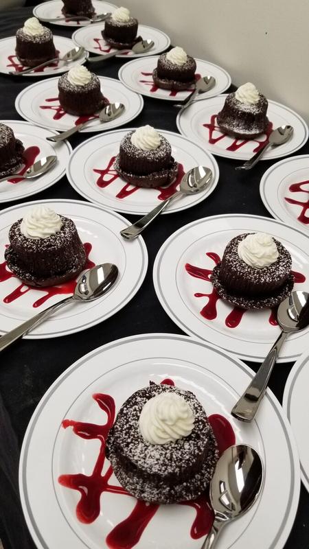 Plated flourless chocolate cakes with raspberry coulis