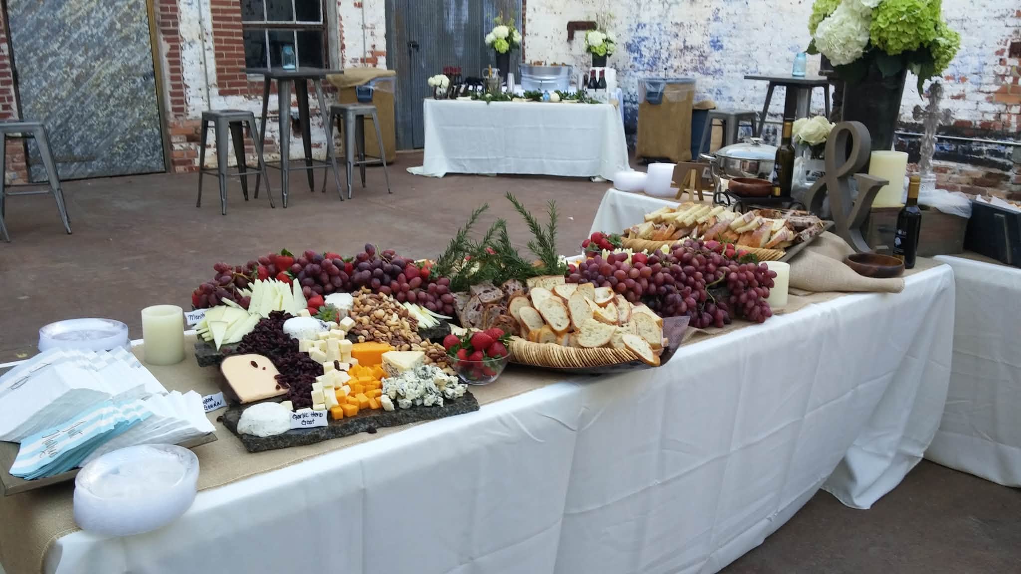 Abundant grazing table with cheeses, fruit, crackers and charcuterie at an event